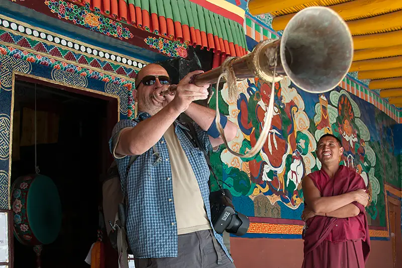 Photographer and Tour Leader Steve Davey in Ladakh blowing a horn